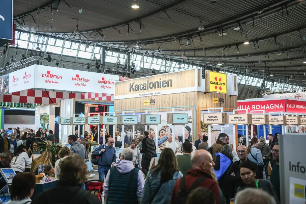 Besucherinnen und Besucher auf der Urlaubsmesse CMT in Stuttgart zwischen internationalen Messeständen, darunter der Katalonien-Stand.